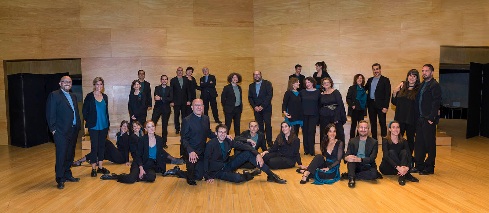 Retrato grupal panorámico de Teselas Ensemble Vocal sobre el escenario